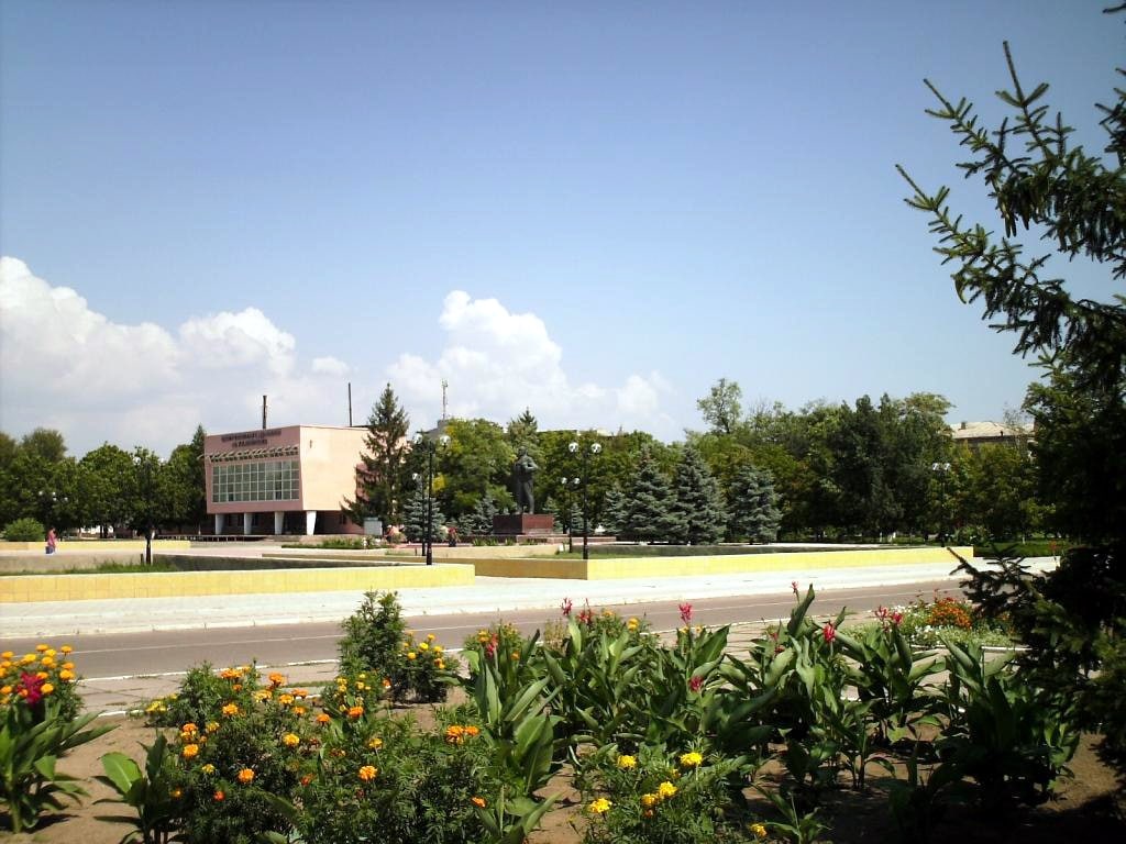 Oleshky’s central square, with trees, flower beds and a civic building, photographed in August 2007.