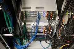 Archive photograph of the rear of Wikimedia Foundation server equipment with dense blue and black network cabling.