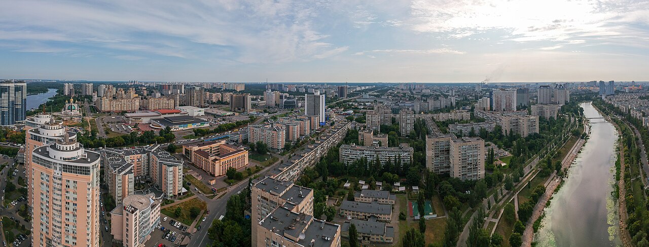 Archive panorama of Kyiv’s Rusanivka district, with apartment buildings, streets and a canal under a cloudy sky.