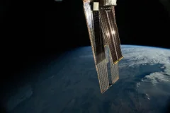 Sunlight reflects from International Space Station solar arrays above Earth in a NASA archive photograph from 17 June 2024.