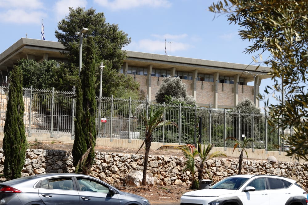 The Knesset building in Jerusalem behind trees and a fence, photographed in September 2025.