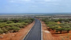 An archive view of a paved road leading toward Moyale, with scrubland on either side, photographed in 2015.